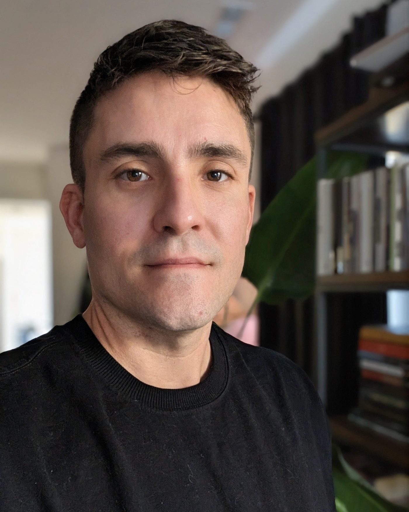 Portrait of Adam Nicholson indoors with plants behind him